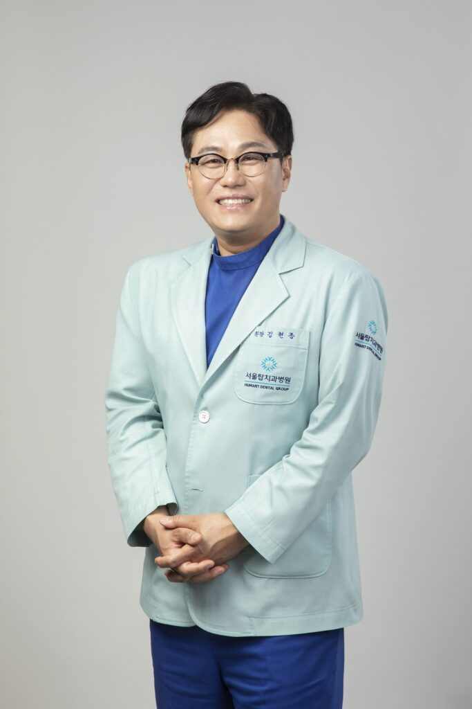 서울탑치과병원 임플란트 담당 원장 프로필 사진 (민트색 가운, 정면)