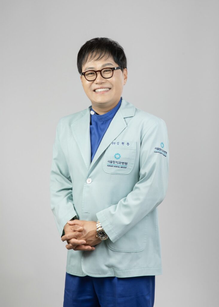 서울탑치과병원 임플란트 담당 원장 프로필 사진 (민트색 가운, 미소)