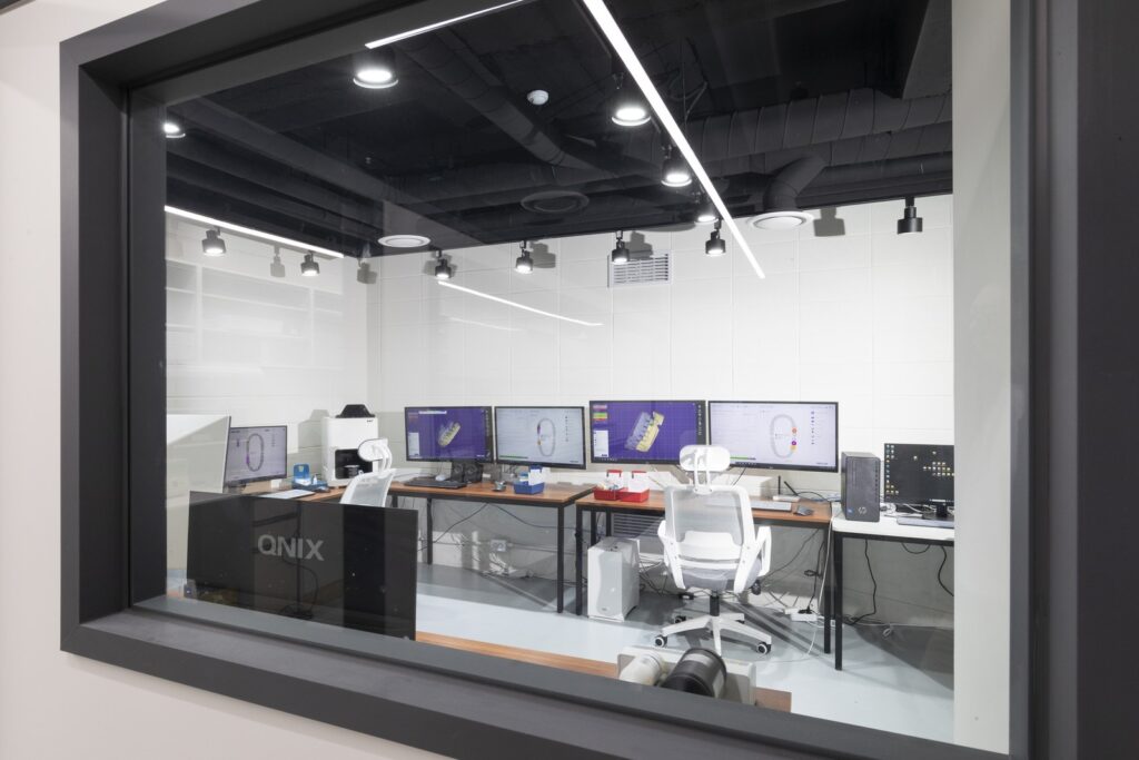 유리창 너머로 보이는 서울탑치과병원 원내 기공실 CAD 디자인실